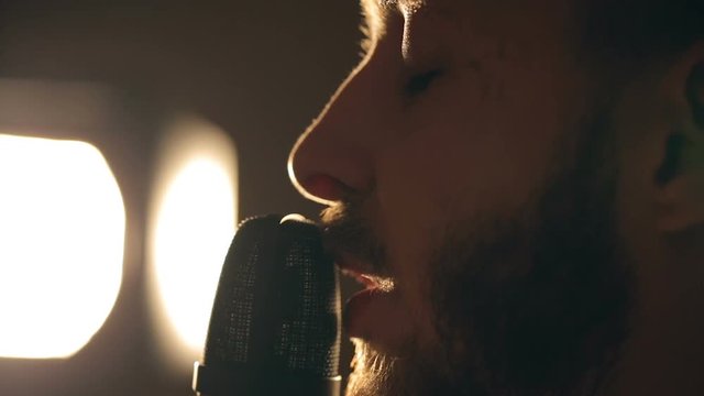 Close up shot of singer in the studio. Close up shot of microphone and man's face