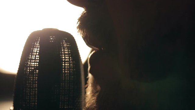 Close up shot of singer in the studio. Close up shot of microphone and man's mouth