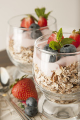 Healthy breakfast, oat meal with fruits: bluebery, strawbery and min, parfait in a glass on a rustic background. Healthy food.