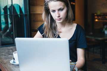 Young beautiful girl studying in a cafe.