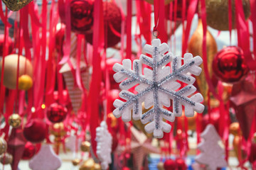 Christmas snowflakes in fair kiosk with red handcrafted xmas decorations.