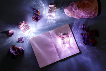 Magic light flatlay with glow and creative book, ultraviolet color