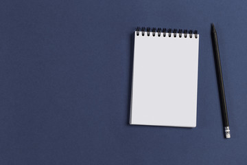 a blank Notepad and pencil on purple background