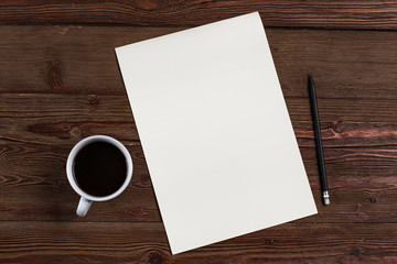 A blank sheet of paper with a pencil and coffee on wooden background