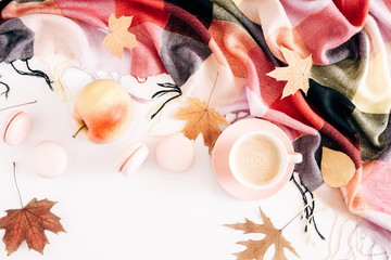 Autumn composition. Cup of coffee, macaroons, checkered plaid, dried leaves on white background. Autumn, cozy fall concept. Flat lay, top view, copy space