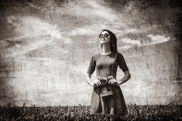 portrait of young beautiful woman with camera in the field. Image in black and white color style