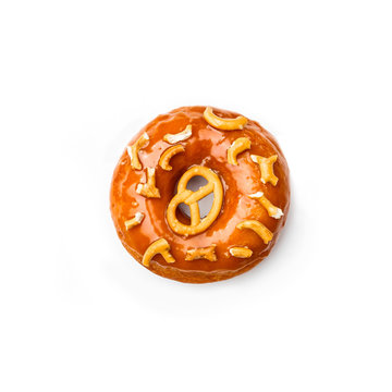 Donut glazed with caramel and pieces of pretzel, isolated on white background. Top view.