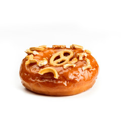 Donut glazed with caramel and pieces of pretzel, isolated on white background. View from side.