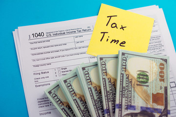 U.S. Individual income tax return. TAX DEDUCTIONS and individual tax return form 1040 with money on table. Lodging your tax return.