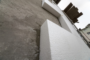 Close-up detail of plastered house wall with rigid styrofoam insulation. Modern technology,...