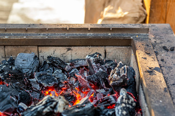 Burning coal in iron brazier. Preparation for barbecue. Fireplace with orange embers