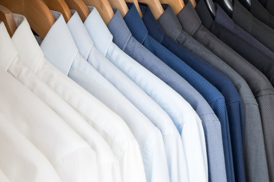 Office Business shirts hanging in a closet ordered by colour