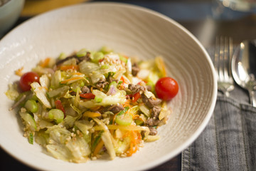 salad with veal, vegetables and herbs, cherry tomato (top view)