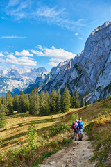 Fototapeta na wymiar healthy and vital senior couple walking/ makes photo in austrian alps with beautiful mountain view