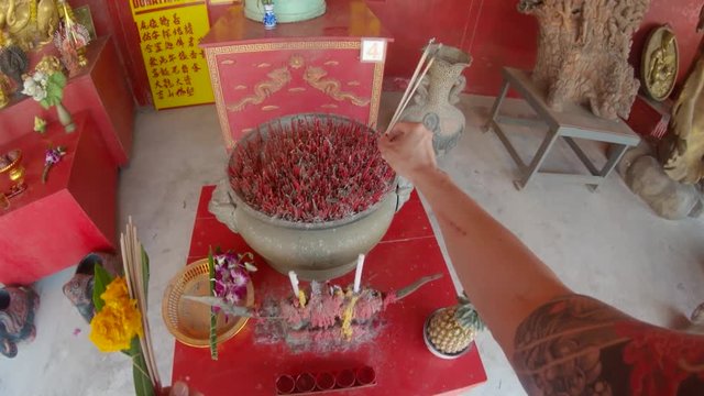 Placing incense in Phuket Thailand Temple, POV