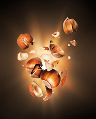 Hazelnuts crushed in the air close-up in the dark