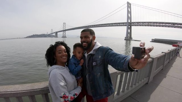 Family takes photo of themselves by Oakland Bay Bridge, POV