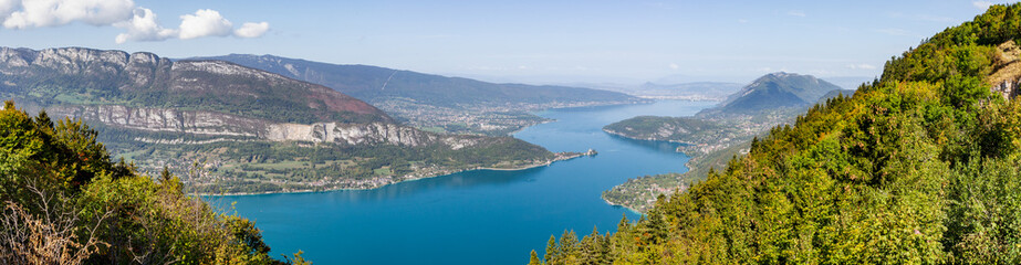 Panoramic view from Lake Annecy in Haute Savoie, France. The turquoise lake is lit by the sun. Some...