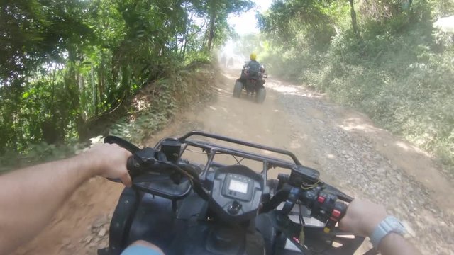 POV, driving ATV on dusty road