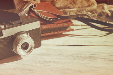 Retro old camera with black leather case and velvet vintage photo on white wooden background with copy space. - obrazy, fototapety, plakaty