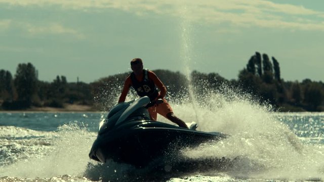 Sportsman riding extreme jet ski on river. Rider drive jet ski in slow motion. Summer extreme lifestyle.