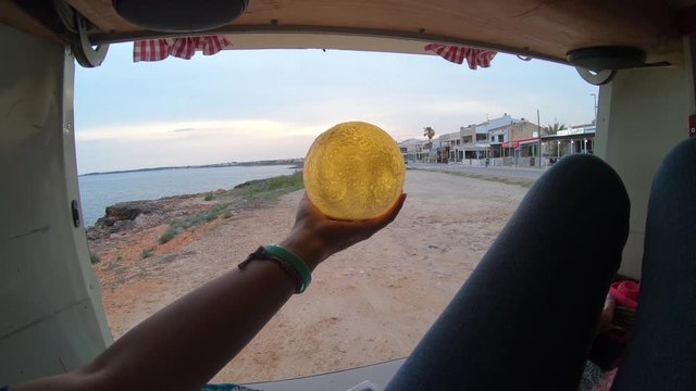 Person Holds Gold Orb In Van, POV