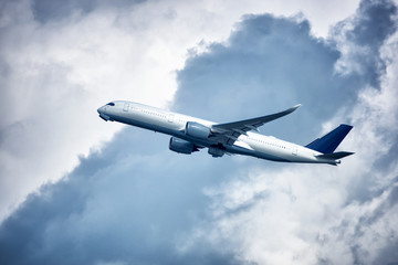 Fototapeta na wymiar Aeroplane in blue cloudy sky.