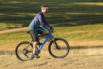 Fototapeta premium Cyclist in shorts and jersey on a modern carbon hardtail bike with an air suspension fork 
