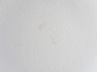Close up of freshly painted white wall with dirt spots on ingrain or woodchip wallpaper or so...