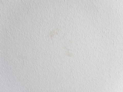 Close up of freshly painted white wall with dirt spots on ingrain or woodchip wallpaper or so called Raufasertapete, the most typical wall design in Germany