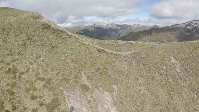 Wide aerial, flying up to mountain ridge in New Zealand
