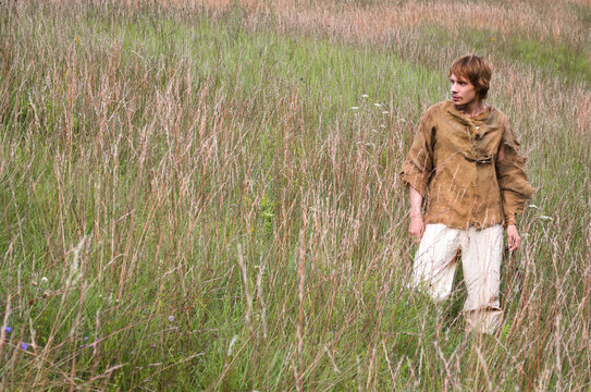 Young Man Dressed As A Medieval Peasant Among Wild Herbs