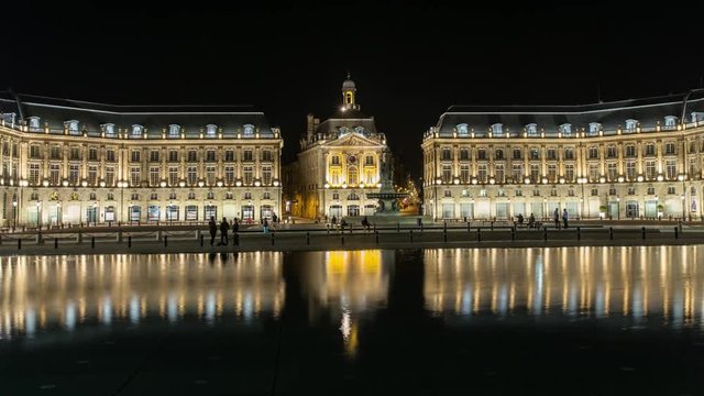 Night time lapse hyperlapse of historic square in Bordeaux with reflection on water, France