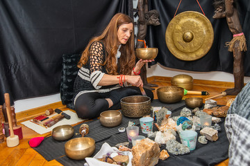 Woman playing a singing bowls also known as Tibetan Singing Bowls, Himalayan bowls. Tibetan Singing...