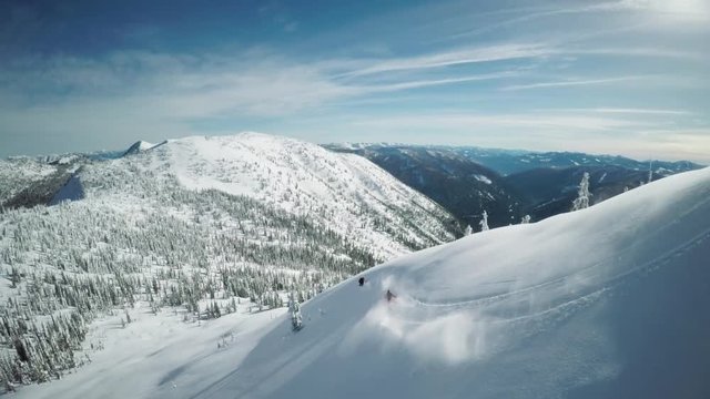 Aerial, skiers shred down slope in British Columbia