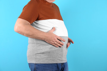 Fat senior man on color background, closeup. Weight loss