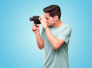 young handsome tanned man with a vintage cinema camera