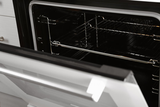 Open empty electric oven with rack, closeup