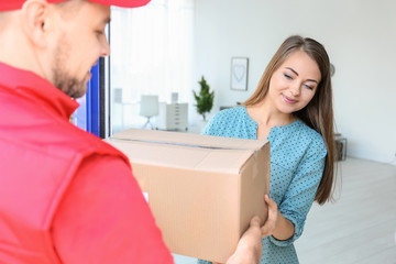 Young woman receiving parcel from courier