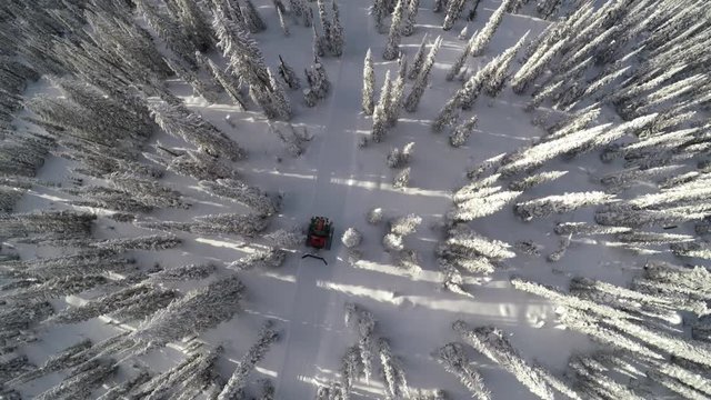 Snowplow travels through British Columbia landscape, overhead aerial