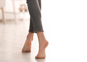 Young woman walking barefoot at home, closeup. Heating concept