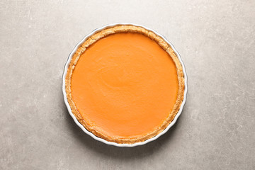 Fresh delicious homemade pumpkin pie on gray background, top view