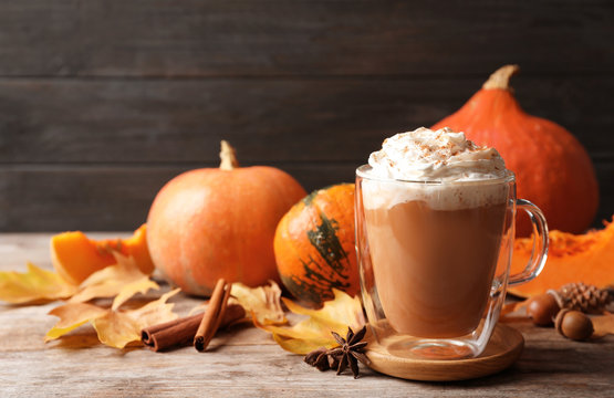 Fototapeta Glass cup with tasty pumpkin spice latte on wooden table