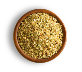 oregano in wood bowl isolated on white background, top view