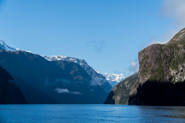 Fototapeta premium rocks and snow capped mountains in Milford Sound, New Zealand