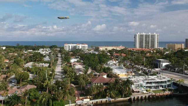 Aerial of a blimp flying across the sky near the ocean and intercostal in Florida