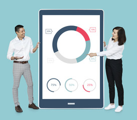 Cheerful diverse people showing pie chart on a tablet