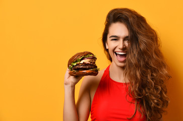 Woman hold big barbecue burger sandwich with hungry mouth happy screaming laughing on yellow background - obrazy, fototapety, plakaty