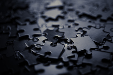 Bunch of Pieces of the puzzle. Close up. Blurred background. Monochrome  concept.