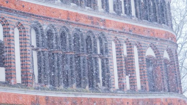 Heavy snowfall in city. Holsten Gate facade view with blizzard